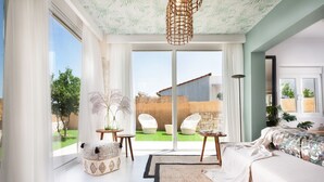 A spacious bedroom with a large bed, a view of the outdoors, and a sliding glass door leading to a patio area.