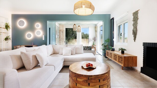 A modern living room with a sectional sofa, a wooden coffee table, and a view of the outdoors.