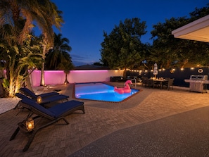 An outdoor pool area with lounge chairs, a flamingo float, and a barbecue grill. - FIFA World Cup 2026 Stay Near Miami Stadium (Pompano Beach)