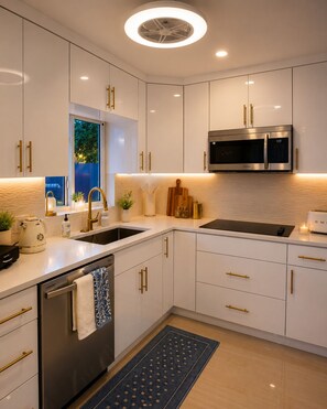 A modern kitchen with white cabinets, a stainless steel microwave, and a built-in oven. - FIFA World Cup 2026 Stay Near Miami Stadium (Pompano Beach)
