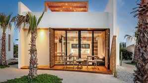A modern house with a spacious interior, large windows, and a patio area. - Casa Tove, a cosy Bungalow in El Pescadero with wifi, yoga deck and pool. (El Pescadero)