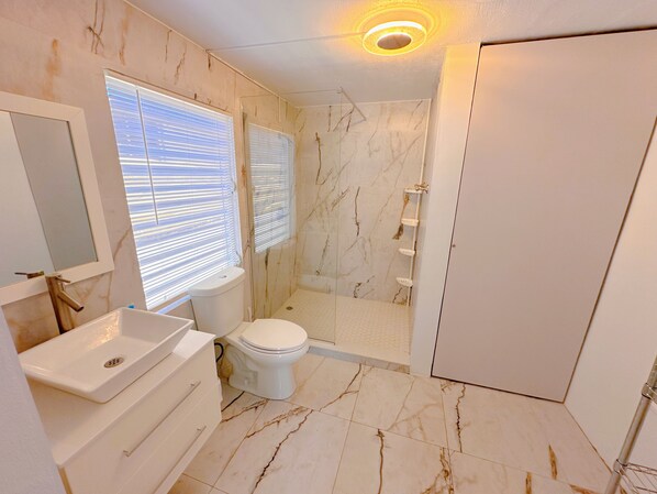 Un baño con inodoro, lavamanos y ducha.