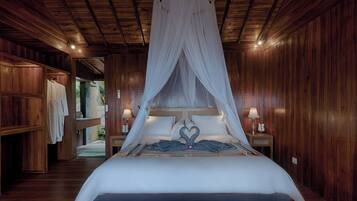A room with a canopy bed, wooden walls, and a nightstand with a lamp.