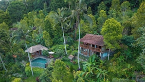A tropical resort with a pool, a dining area, and a large house surrounded by dense vegetation. - Loid's di Lempuyang (Karangasem)