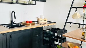 A modern kitchen with black cabinetry, a wooden countertop, and a black hanging shelf. - Vacation apartment in Torrox-Park. Modern, bright, cozy, quiet, dogs welcome. (Torrox)