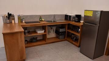Cocina compacta con lavabo, microondas y refrigerador.