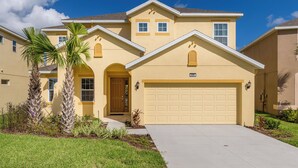 A two-story house with a garage, a front door, and a small porch. - ⛱ Providence Resort - 5★ Golf Community - Lakeview Home – Communal Amenities☀ (Davenport)