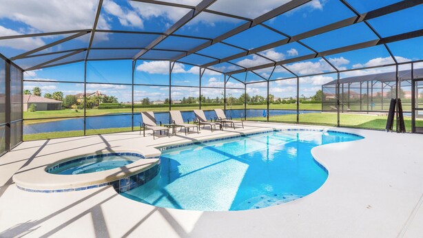 A covered swimming pool with lounge chairs and a hot tub, surrounded by a metal frame and glass panels. - ⛱ Providence Resort - 5★ Golf Community - Lakeview Home – Communal Amenities☀ (Davenport)