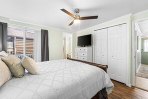 A bedroom with a bed, a ceiling fan, a television, a dresser, and a sliding door. - 3b 3ba Home, Pet allowed, 2 Pools, Hot Tub, Gym (Panama City Beach)