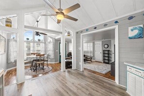 A spacious interior with a dining area, a living room, and a kitchen, connected by open doorways. - 3b 3ba Home, Pet allowed, 2 Pools, Hot Tub, Gym (Panama City Beach)