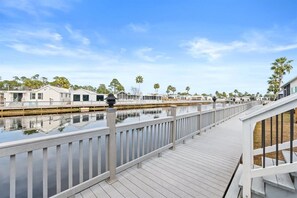A waterfront property with a wooden deck and a view of the water.