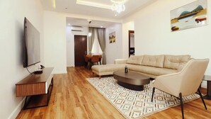 Una sala moderna con sofá, mesa de centro, televisor y alfombra estampada.