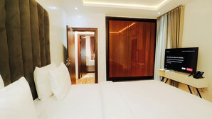 Una habitación de hotel con una cama grande, un televisor y un armario.