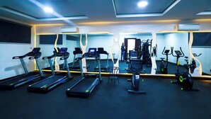 Un gimnasio con cintas de correr, elípticas y un muro de espejos.