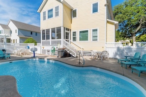 A swimming pool with a deck, chairs, and a covered area with a staircase. - Charming pet-friendly home w/ pool & family-friendly community amenities! (Corolla)