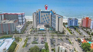 Hotel à beira-mar com vários andares, estacionamento e vista para o oceano.