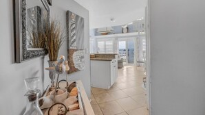 Cocina moderna con armarios blancos, encimera de granito y vistas al exterior.