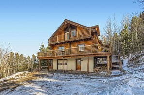 A two-story log cabin with a balcony, surrounded by a snowy landscape and trees. - Valley View Vistas - Dog-Friendly Cozy Retreat w/ VIEWS! (Nederland)