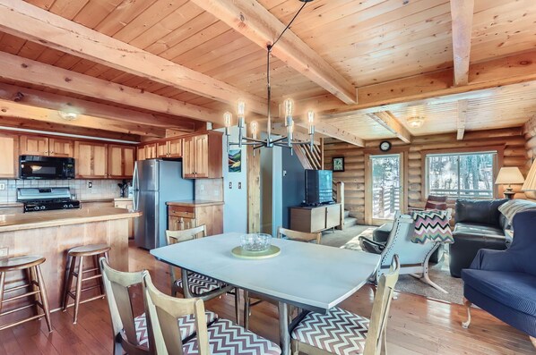 A wooden cabin interior with a kitchen, dining area, and living room. - Valley View Vistas - Dog-Friendly Cozy Retreat w/ VIEWS! (Nederland)