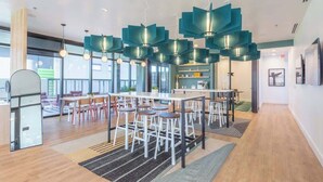 A modern interior with a central dining area, bar stools, and pendant lighting. - Boulevard Stays Modern Highrise STU Sky Pool, Gym 09 (Phoenix)