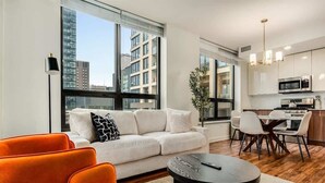 Um apartamento moderno com sala de estar, sala de jantar e cozinha.