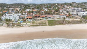 A coastal residential area with houses, a beach, and a view of the ocean. - Casa Beira Mar enseada dos Corais-SH098D (Cabo de Santo Agostinho)