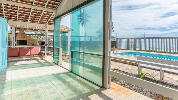 A covered outdoor area with a pool, a barbecue, and a seating area with a view of the ocean. - Casa Beira Mar enseada dos Corais-SH098D (Cabo de Santo Agostinho)