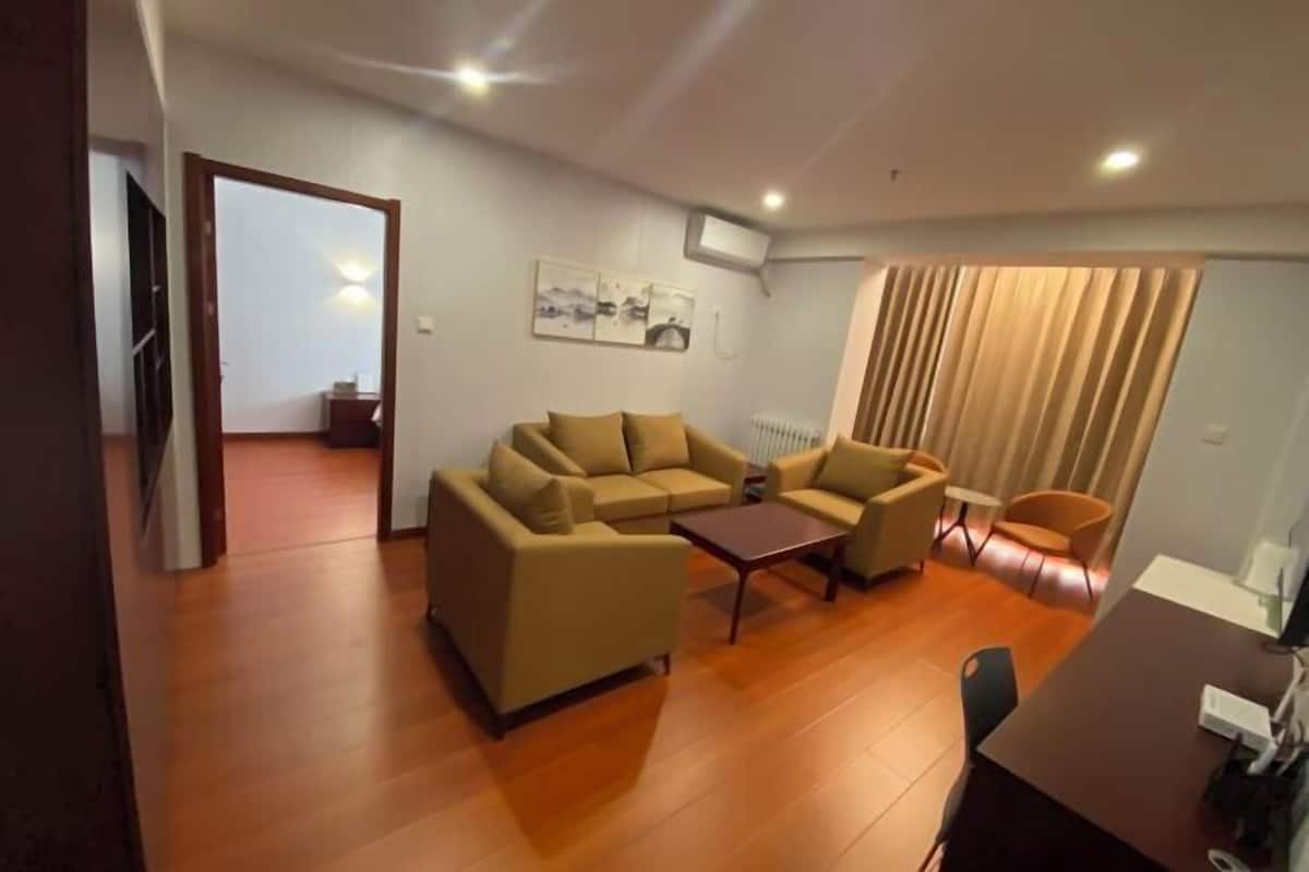 Uma sala de estar com um conjunto de sofá, uma mesa de centro e um espaço de jantar com mesa e cadeiras.