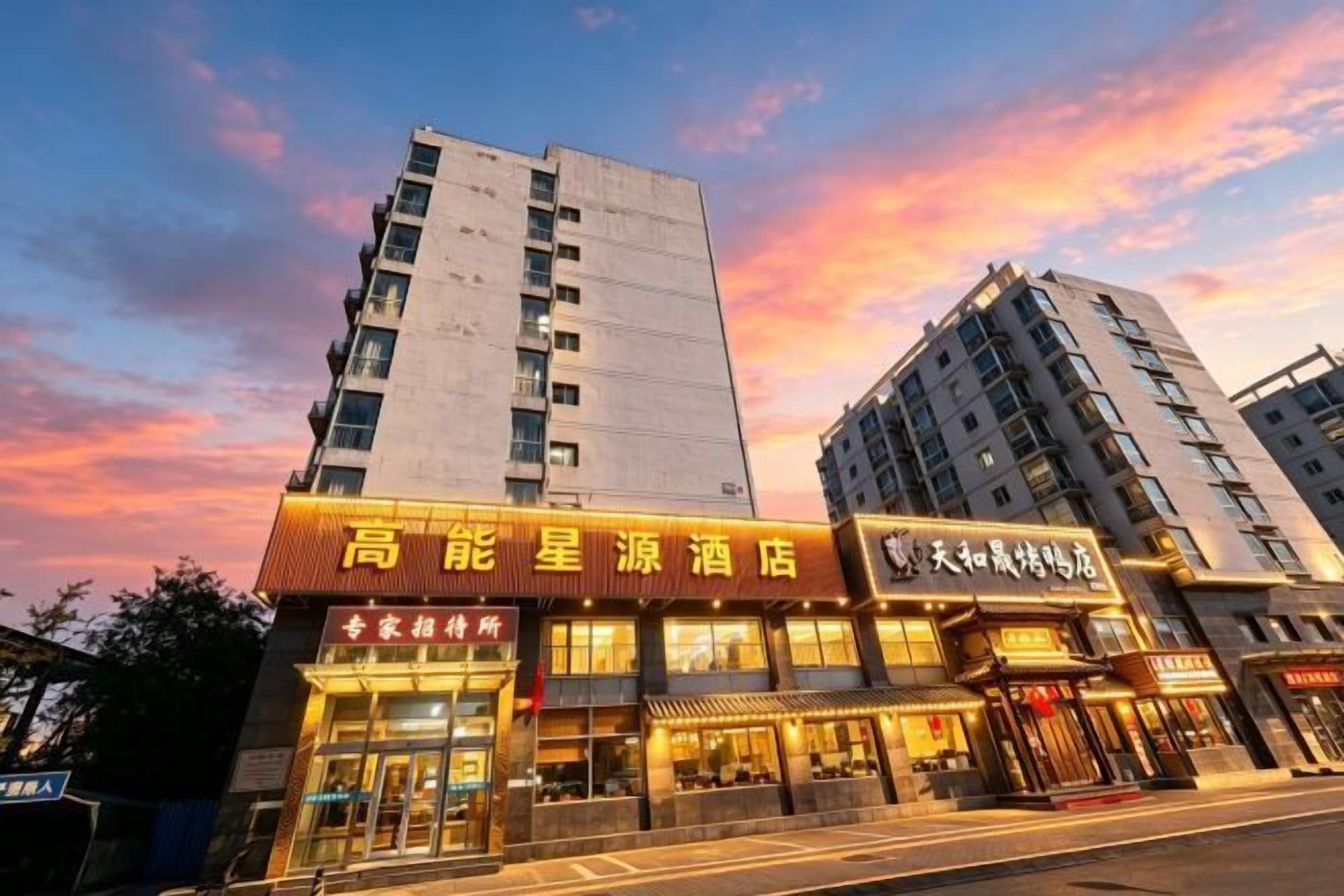 A hotel with a prominent sign, multiple floors, and a clear sky in the background.