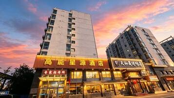 A hotel with a prominent sign, multiple floors, and a clear sky in the background.