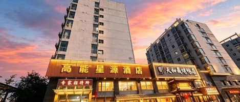 A hotel with a prominent sign, multiple floors, and a clear sky in the background.