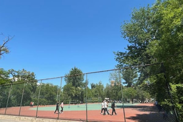 An outdoor tennis court surrounded by trees. - GaoNeng XingYuan Hotel (Beijing)