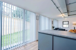 A modern kitchen with a large window, a counter, and a view of the outdoors. - Modern 2 Bedroom Apartment Near M6 Junction 21 (Warrington)