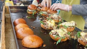 A street food vendor preparing burgers on a griddle. - London Apartment - Sleeps 3-city Escape- Balcony (London)