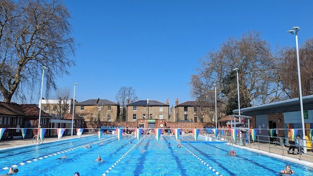 A swimming pool with multiple lanes, surrounded by trees and buildings. - London Apartment - Sleeps 3-city Escape- Balcony (London)
