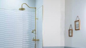 Un baño con ducha, inodoro y paredes de azulejos.