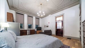 Un dormitorio con una cama grande, un aparador, un televisor y un escritorio.