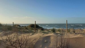 A beach with sand dunes, sparse vegetation, and a view of the ocean. - La Bouteille à la Mer, Maison d'architecte avec jacuzzi (Barneville-Carteret)
