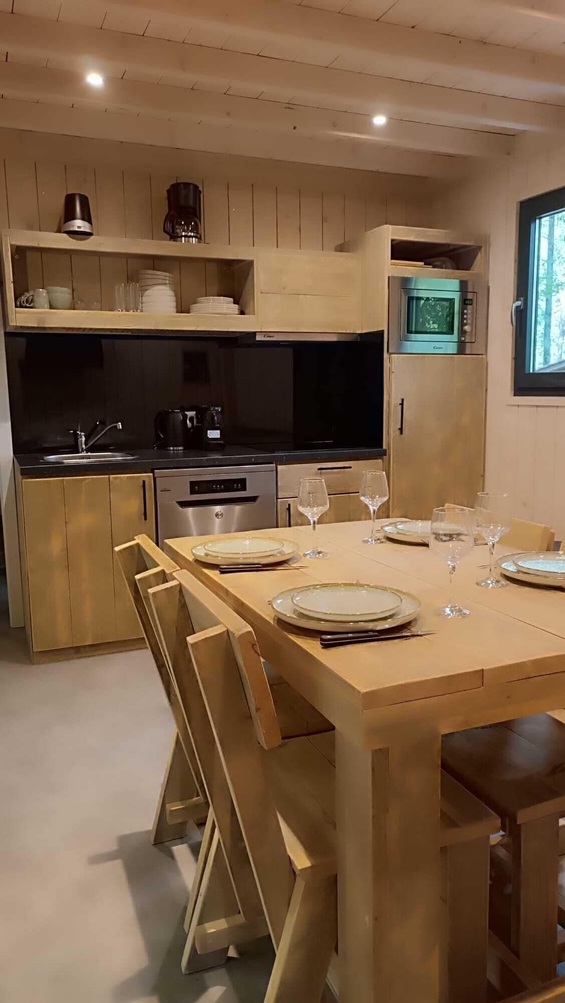 A modern kitchen with wooden cabinetry, a built-in oven, and a dining area set for six with a wooden table and chairs.