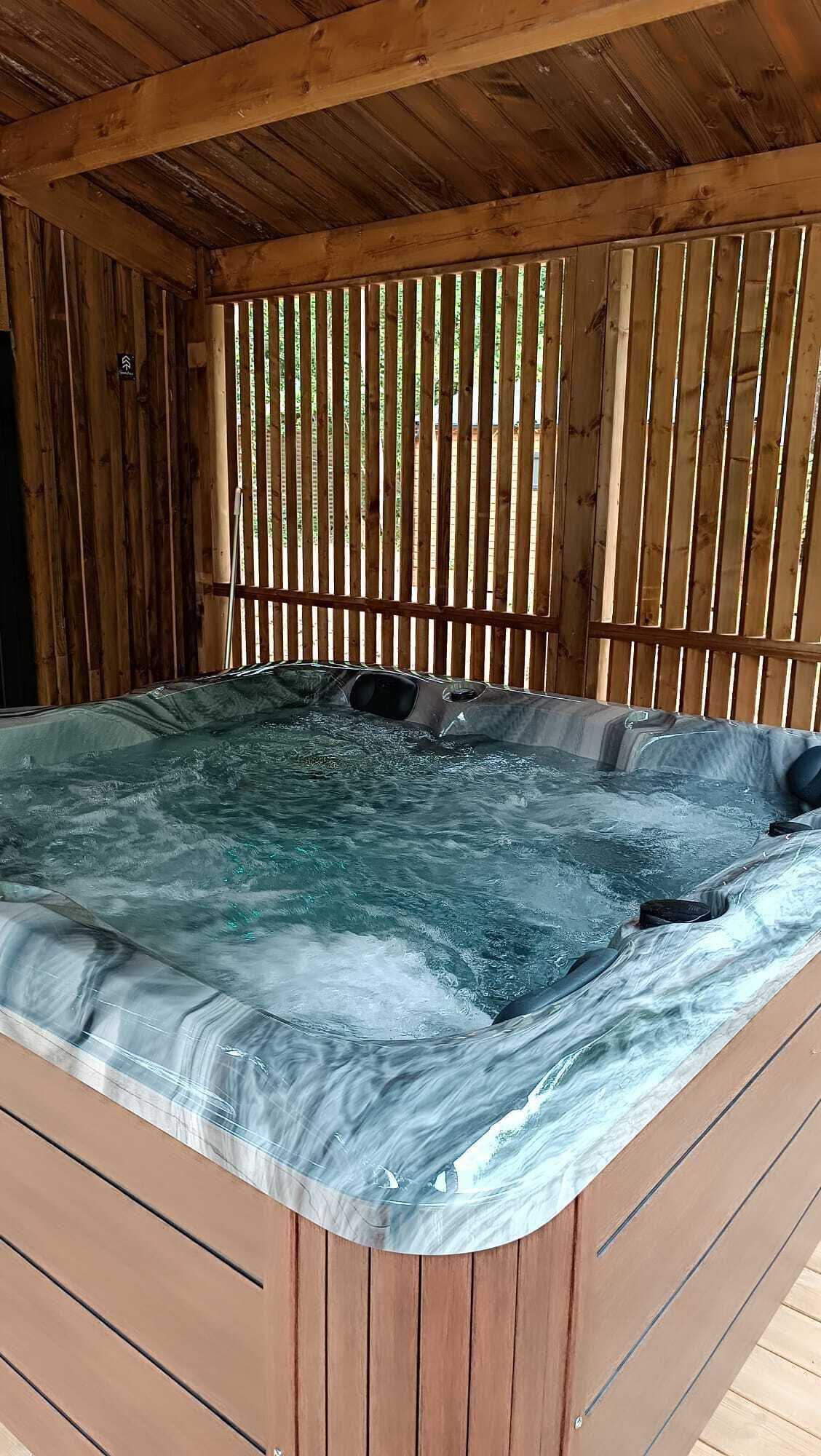 Uma banheira de hidromassagem com um deck e teto de madeira.