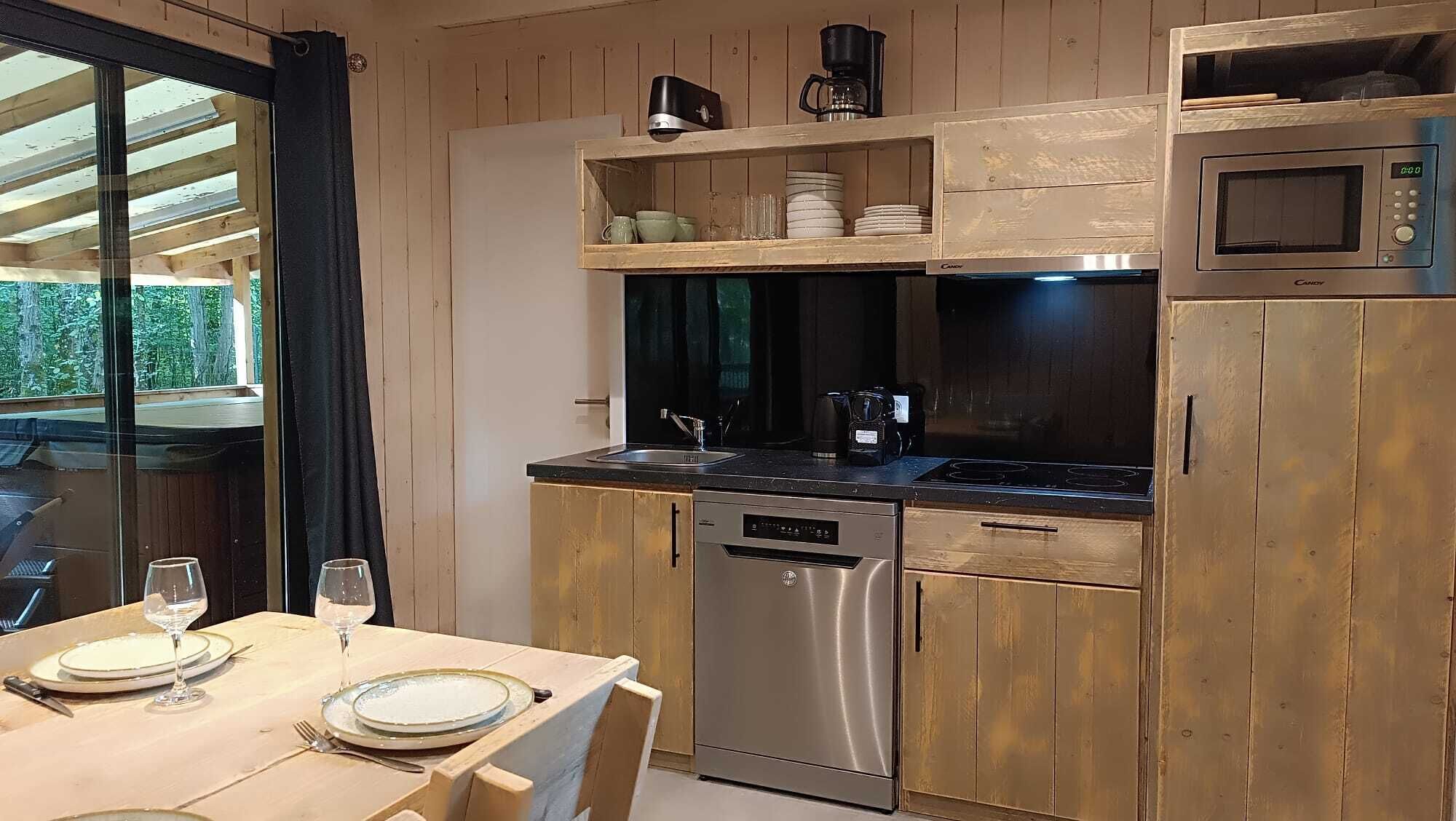 A compact kitchen with a dishwasher, stove, and microwave.