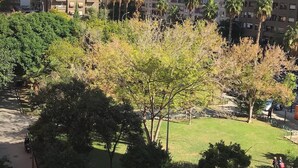 A residential area with multi-story apartment buildings, a grassy park area, and a clear blue sky.