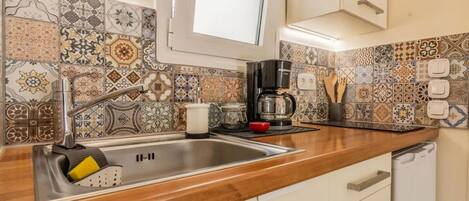 Coffee/tea maker, cookware/dishes/utensils, paper towels, dining tables