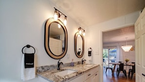 A bathroom with two large mirrors, a vanity with a sink, and a towel rack labeled "Makeup". - Cozy Riverside Cottage—Quiet—3-Beds—Fully Updated! (Belmont)