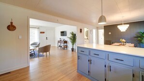 A spacious kitchen with a central island, wooden flooring, and modern pendant lighting. - Cozy Riverside Cottage—Quiet—3-Beds—Fully Updated! (Belmont)
