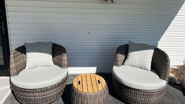Two wicker chairs with cushions, a small wooden table, and a floral wreath on a white wall. - Retro Retreat! 2BR, 1 Bath Home with WiFi, AC in wonderful Bristol, VA (Bristol)