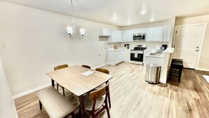 A modern kitchen with white cabinets, a stainless steel microwave, and a built-in oven.