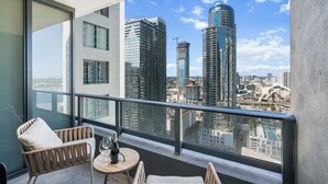 A balcony with a view of high-rise buildings and a clear sky.