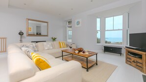 A modern living room with a sofa, coffee table, and a television. - Heatherleigh, Carbis Bay – Sleeps 8 – Sea Views – Dog-Friendly - On-Site Parking (Carbis Bay)
