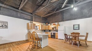 Une cuisine spacieuse dotée de meubles en bois, d’un îlot central et d’un coin repas avec des chaises.